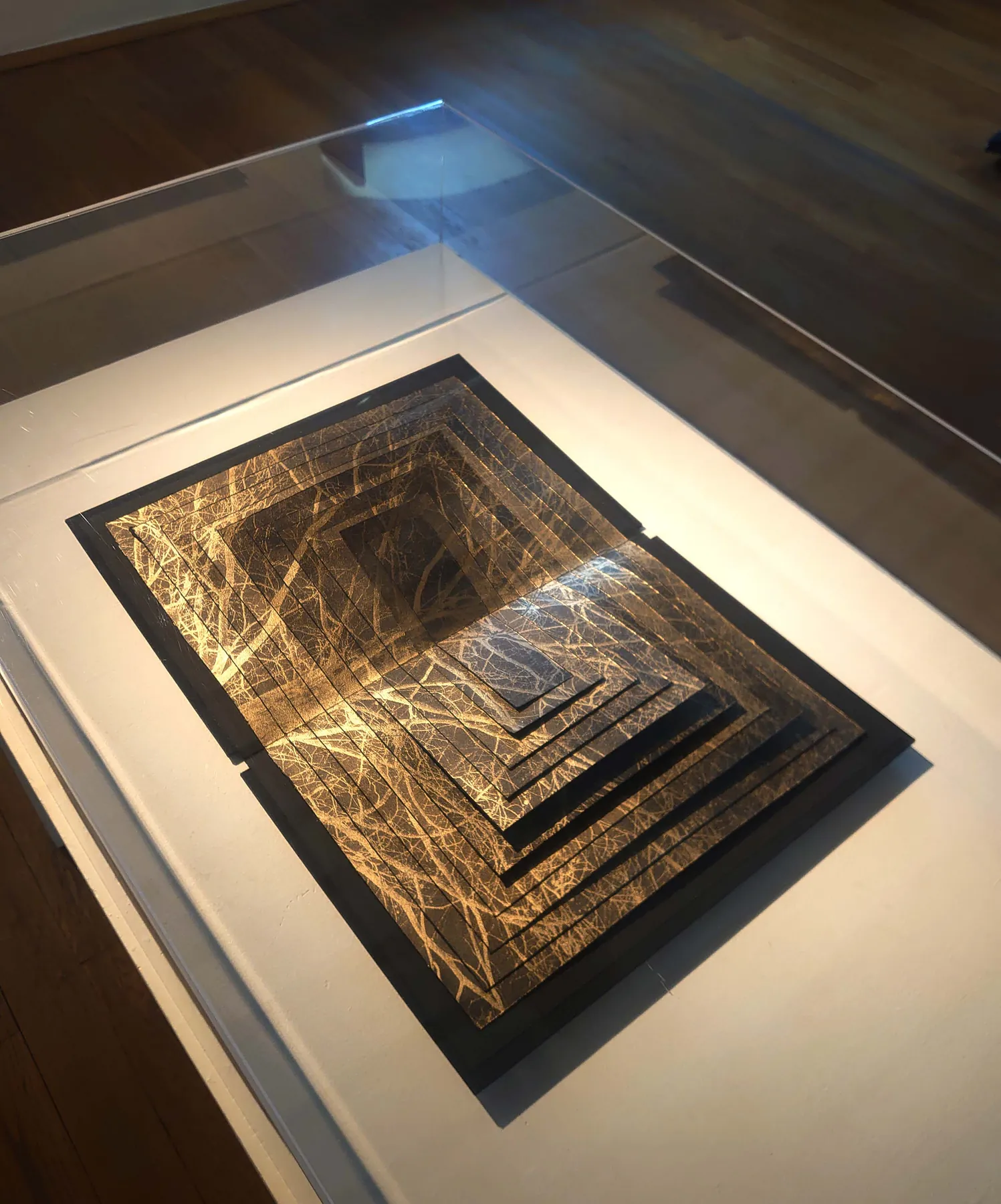 «Estratos de un bosque», libro de artista sobre pan de oro, expuesto en vitrina